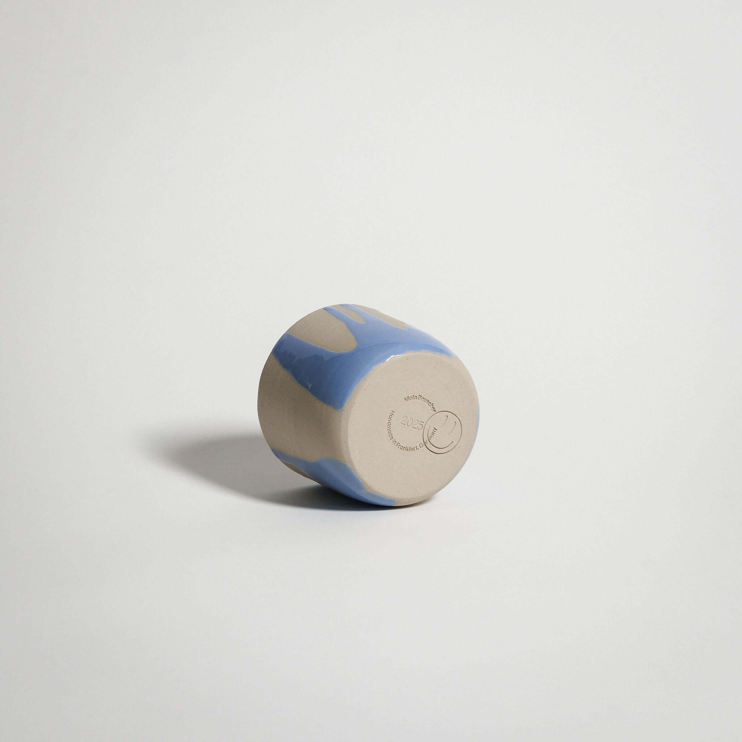 Handcrafted blue stoneware coffee cup featuring glossy glaze and unique wheel-thrown design.