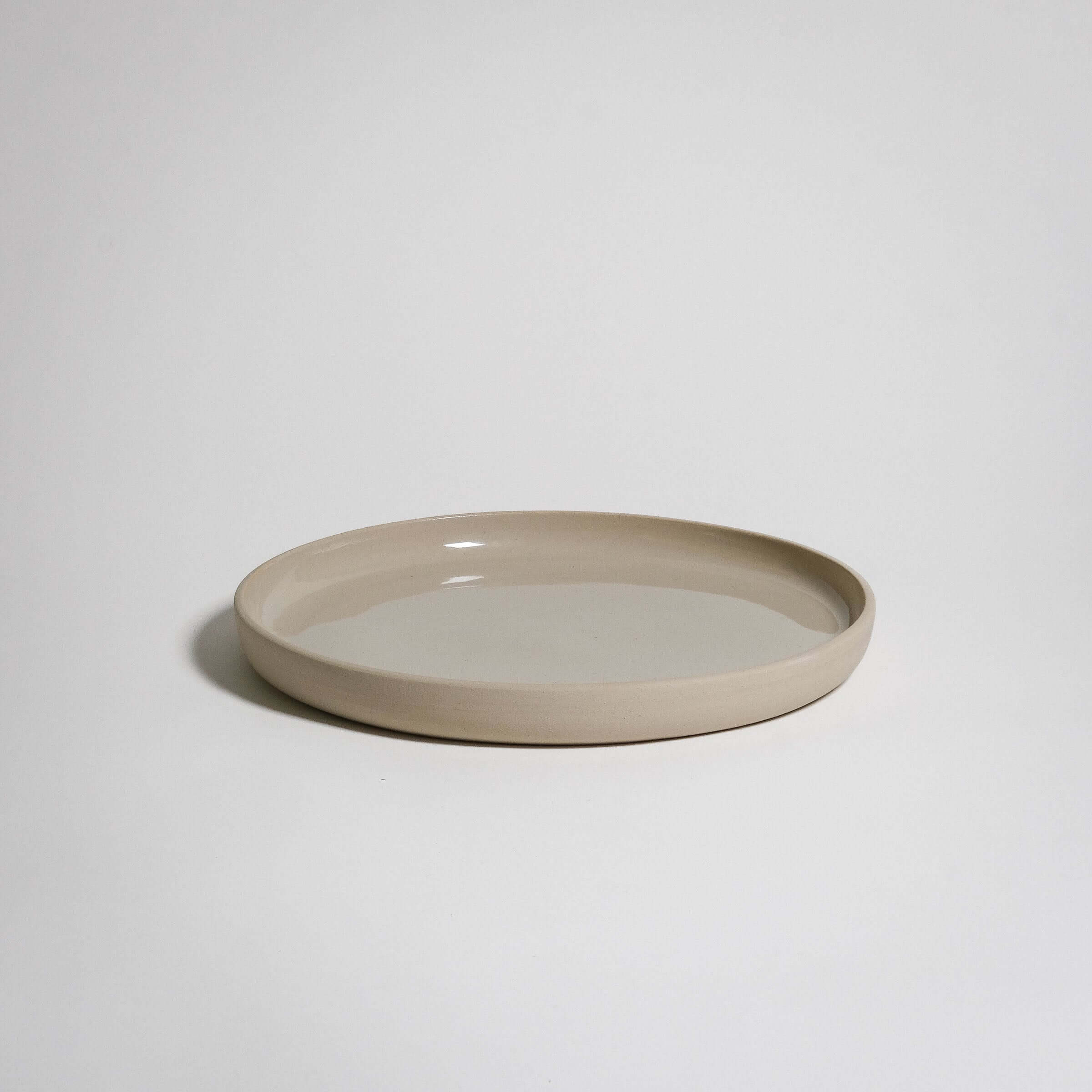 Medium Plate with a bit higher rim. The outside is left raw without glazing and the surface is glazed transparent.