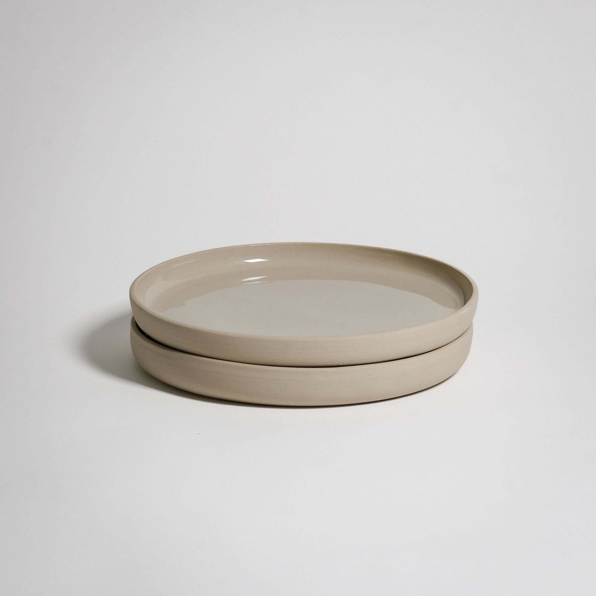 A Medium Plate with a higher rim. The outside is unglazed and the surface is glazed in transparent glaizing