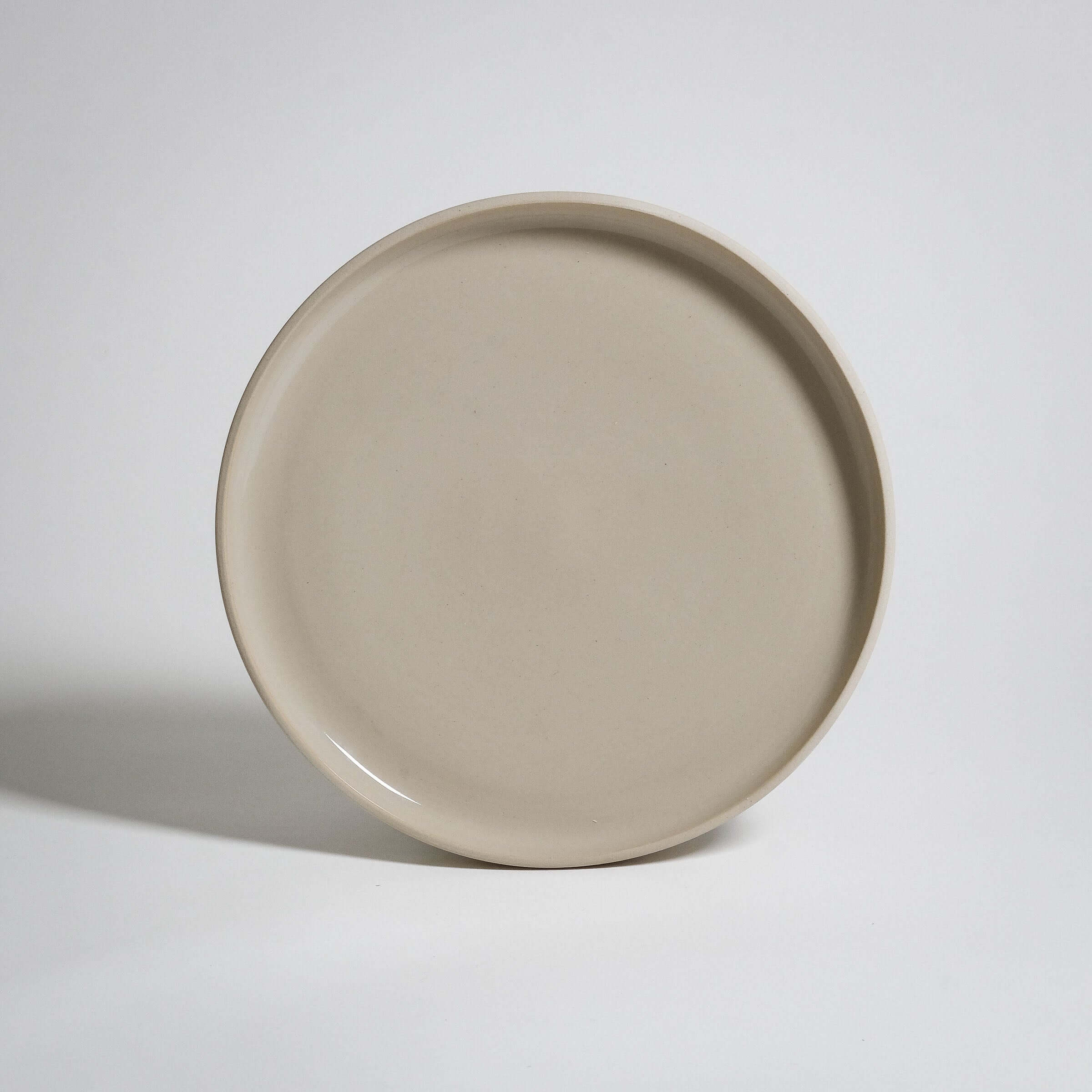 Medium Plate with a bit higher rim. The outside is left raw without glazing and the surface is glazed transparent.