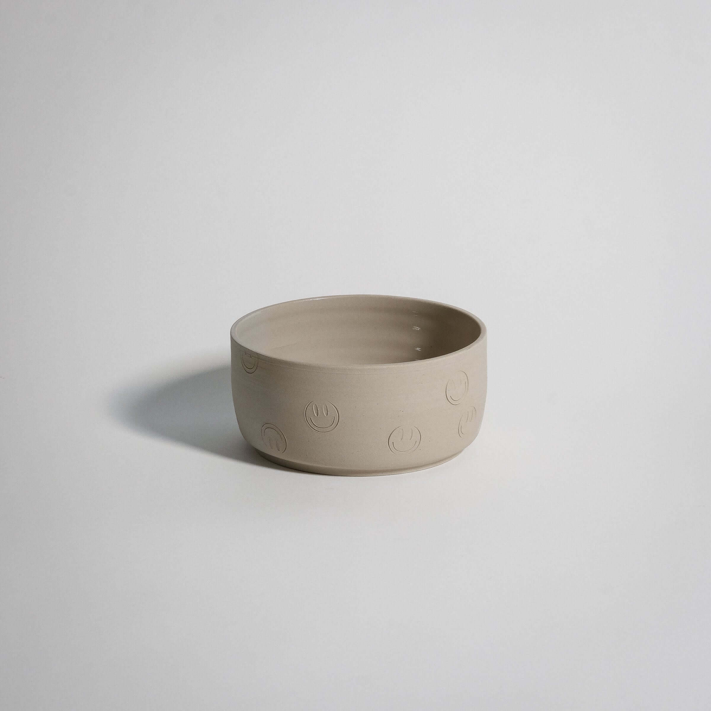 Smiley Breakfast Bowl Creme made from grey stoneware, featuring happy face stamps and a glossy interior glaze.