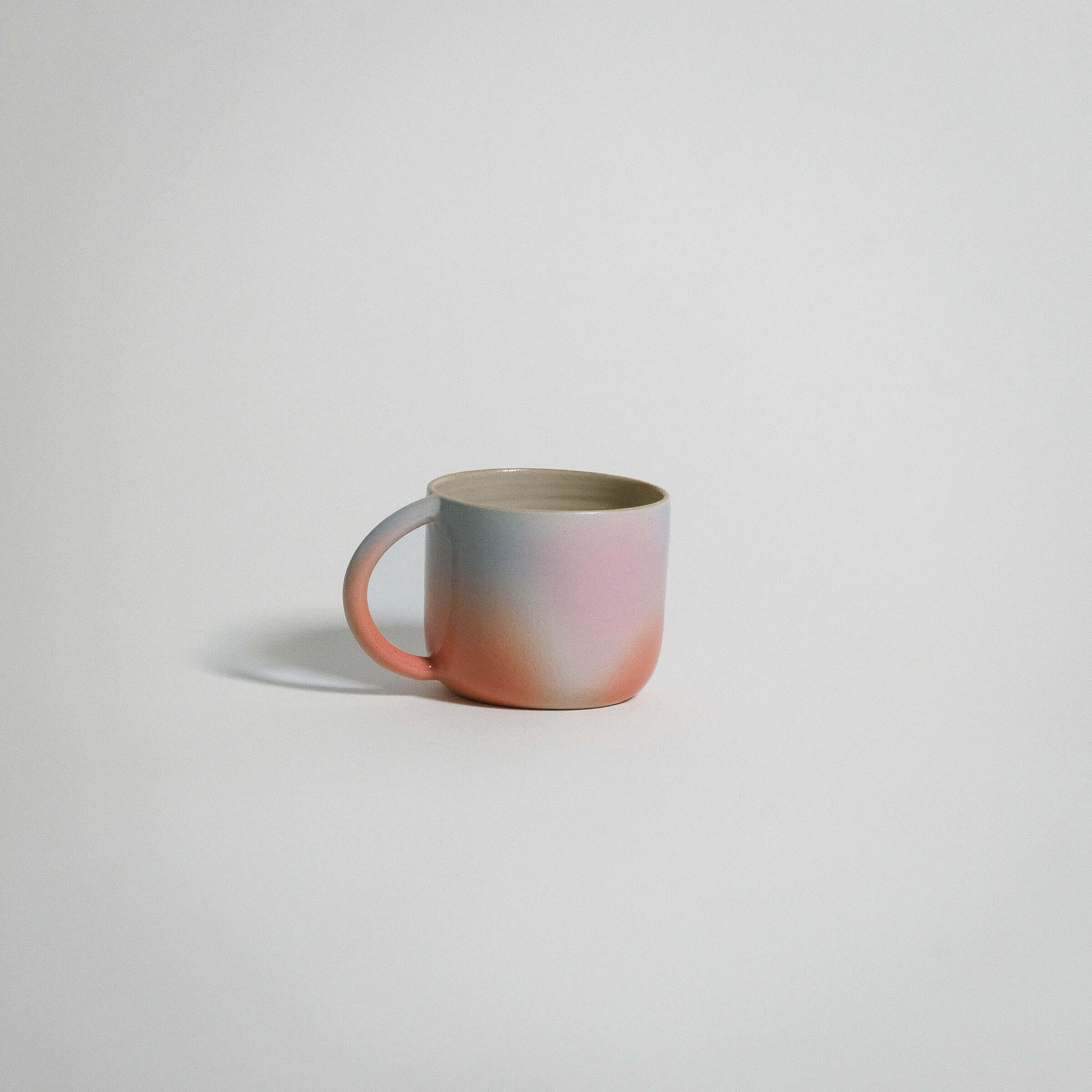 Dawn Variation Mug featuring a grey stoneware clay body with glossy pink, blue, and orange glaze perfect for coffee or tea.