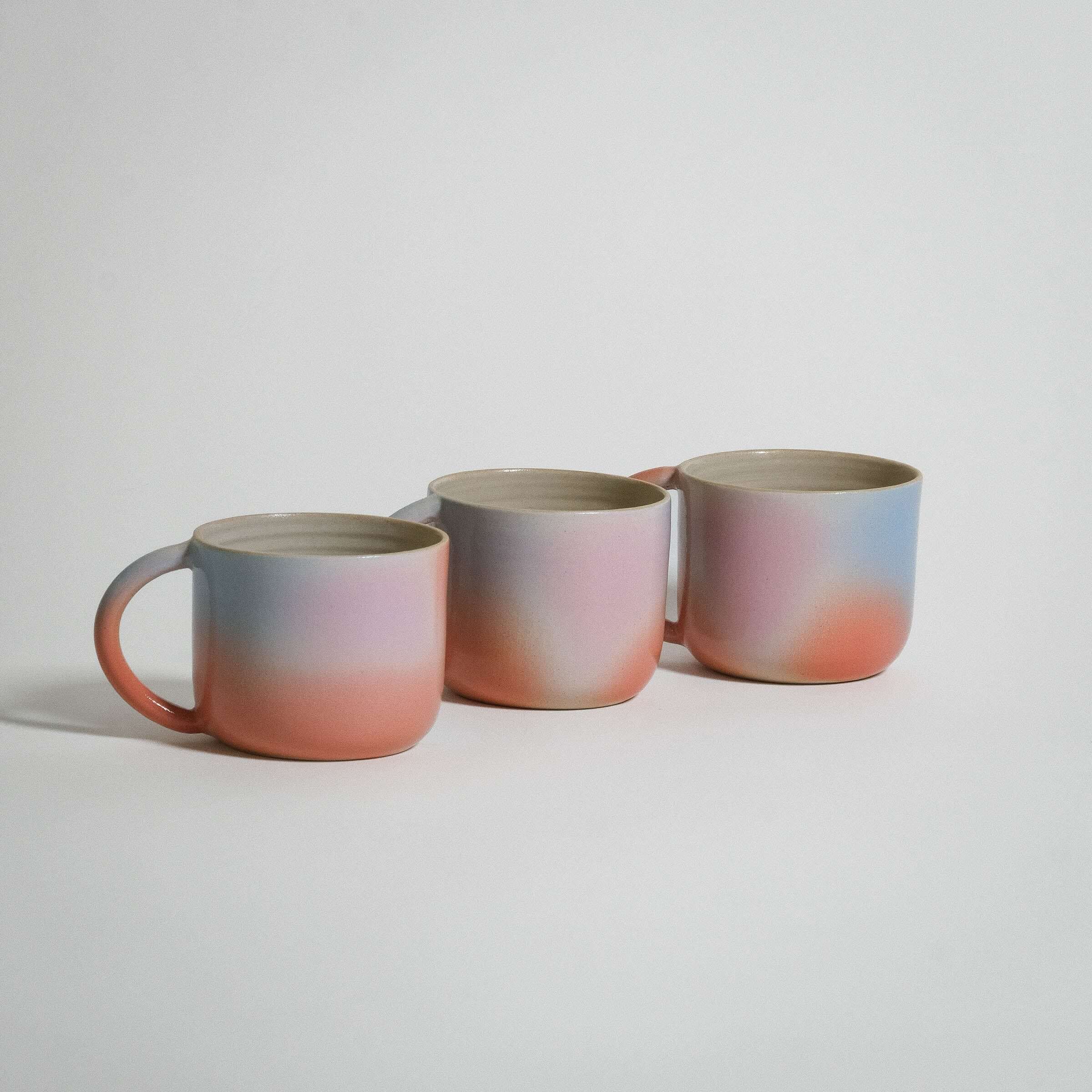 Dawn Variation Mug set in grey stoneware with glossy orange, blue, and pink glazes for coffee or tea.