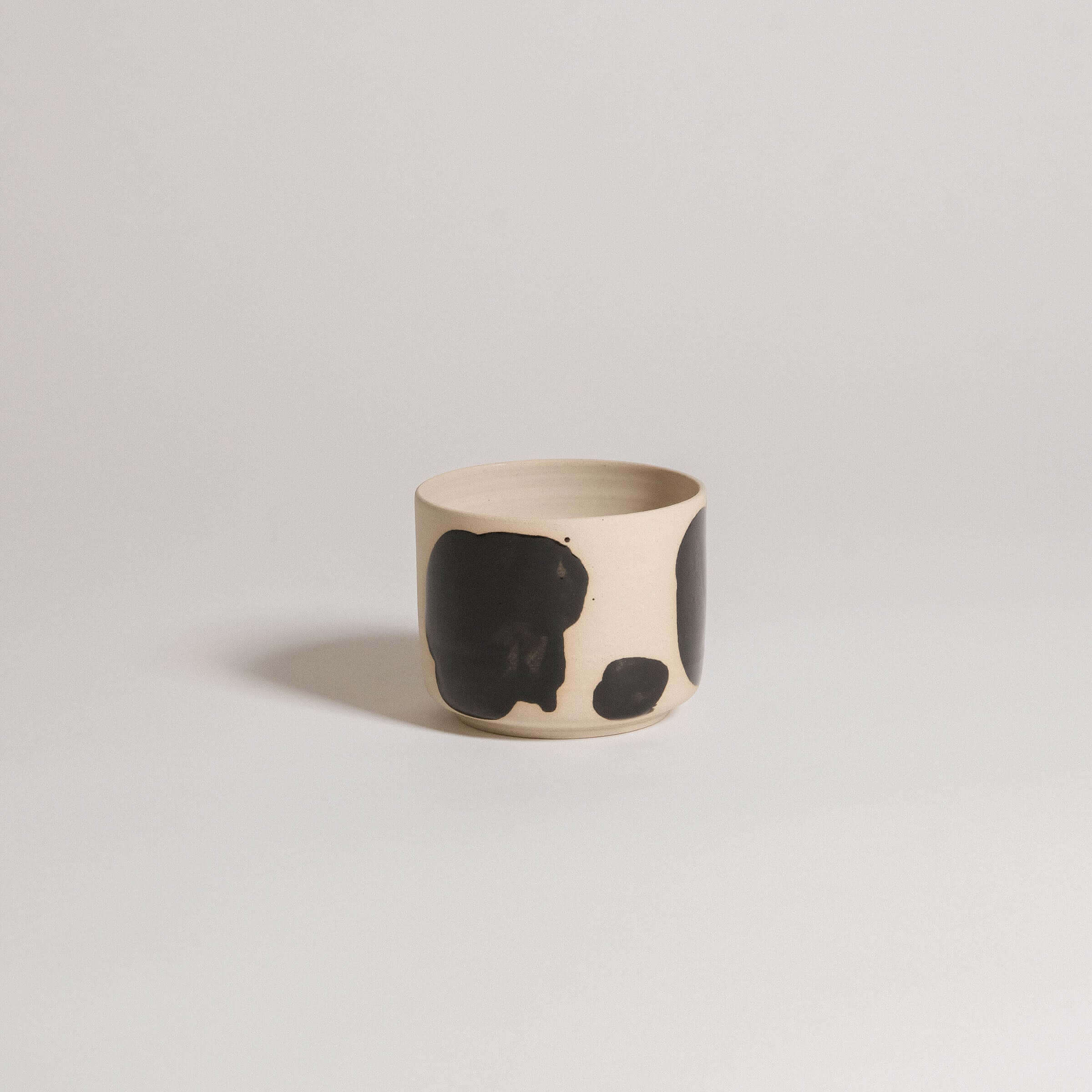 Set of 4 Nomi Pepe coffee cups in grey stoneware with glossy black hand-painted design.