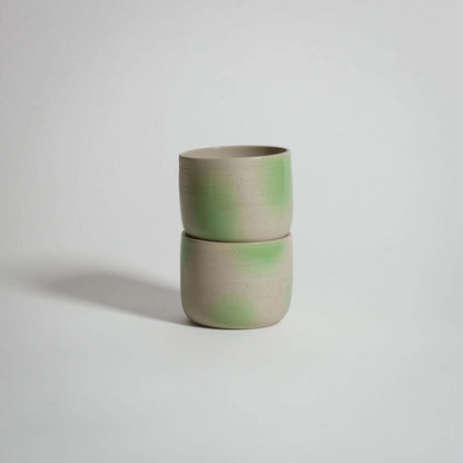 Wheel-thrown grey stoneware coffee cup, glossy interior, lime green spray paint on exterior.
