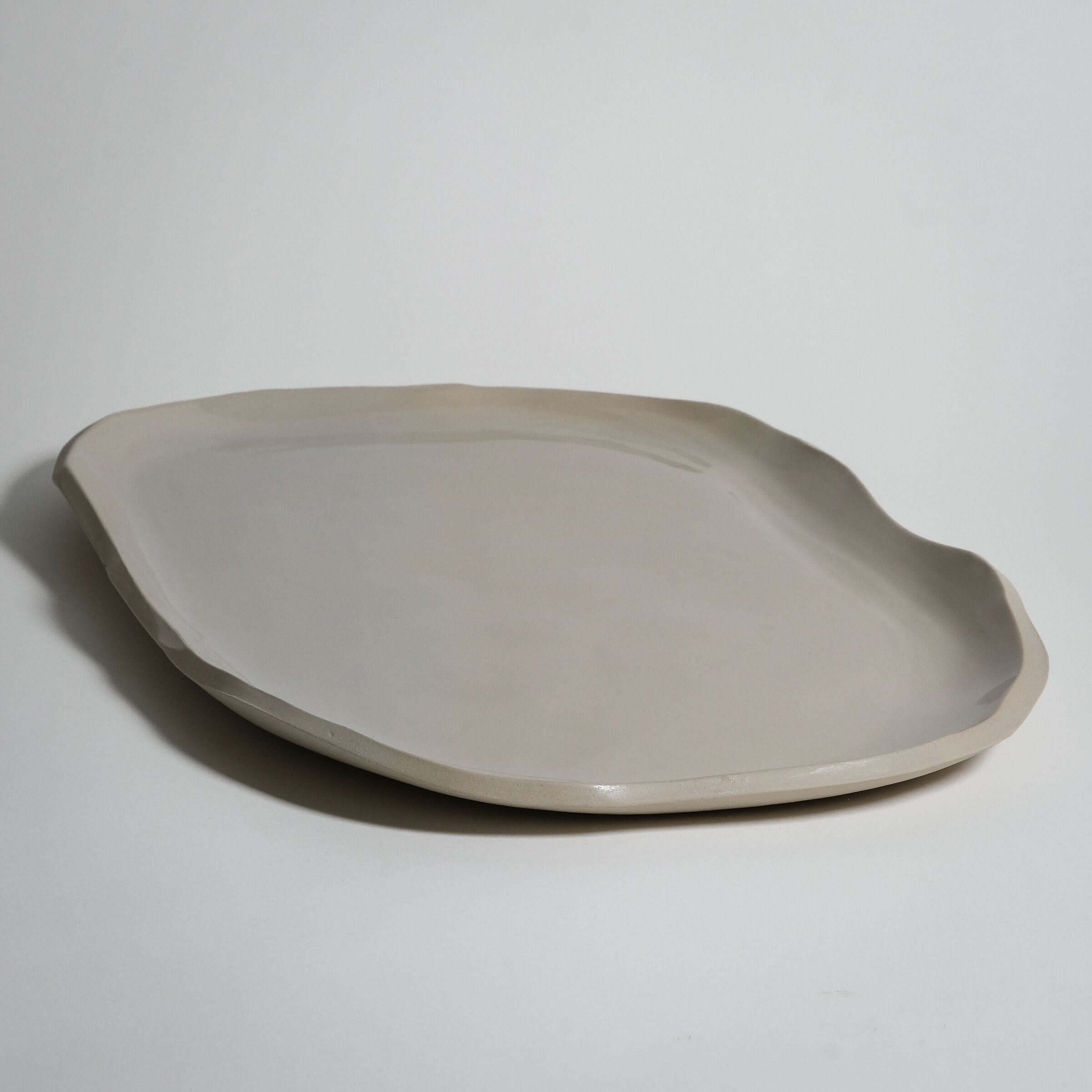 Wide serving tray in creme color, handcrafted stoneware ceramic with elegant transparent glaze, perfect for everyday use.