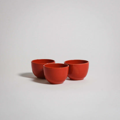 Three red espresso cups standing next to each other