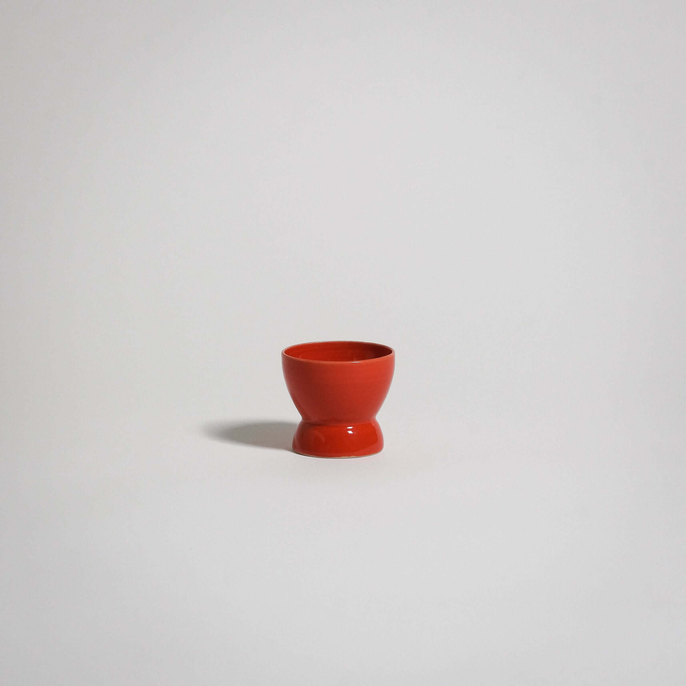 Handmade red egg cup in stoneware with a glossy finish, ideal for everyday use and food-safe.