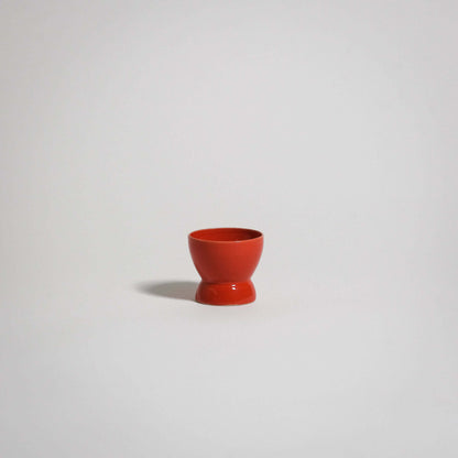 Handmade red egg cup in stoneware with a glossy finish, ideal for everyday use and food-safe.