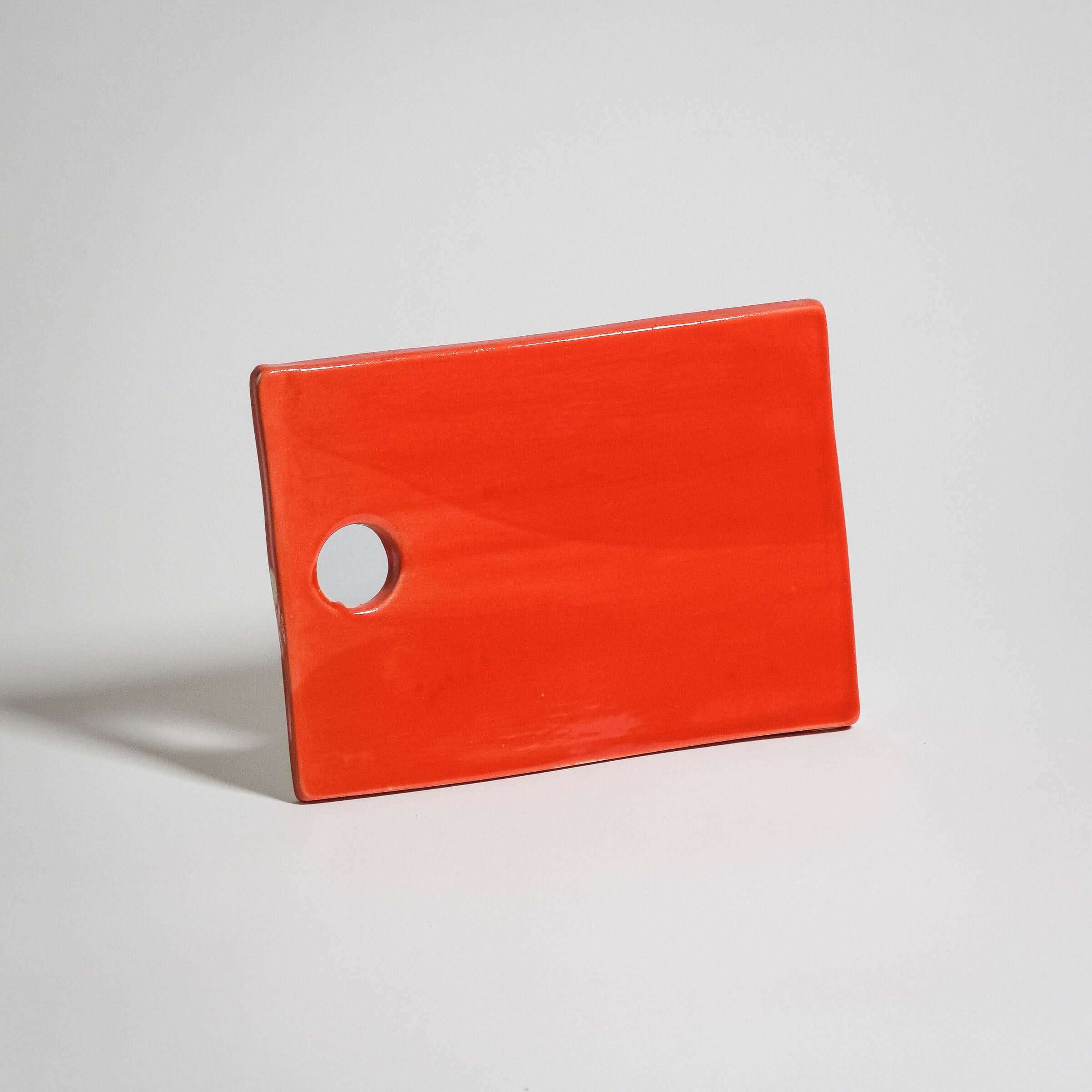 Handmade red serving board in high-quality stoneware with glossy glaze, durable and food-safe.
