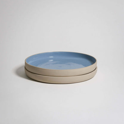 A Medium Plate with a higher rim. The outside is unglazed and the surface is glazed in blue glaizing