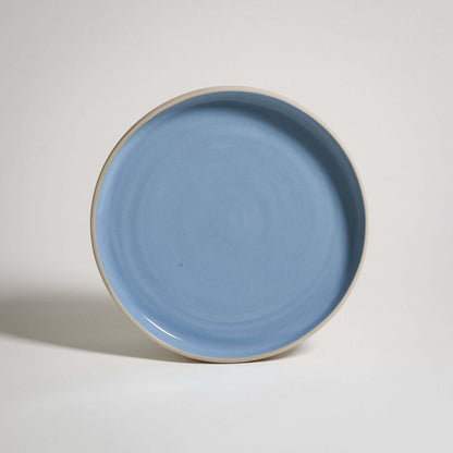 A Medium Plate with a higher rim. The outside is unglazed and the surface is glazed in blue glaizing