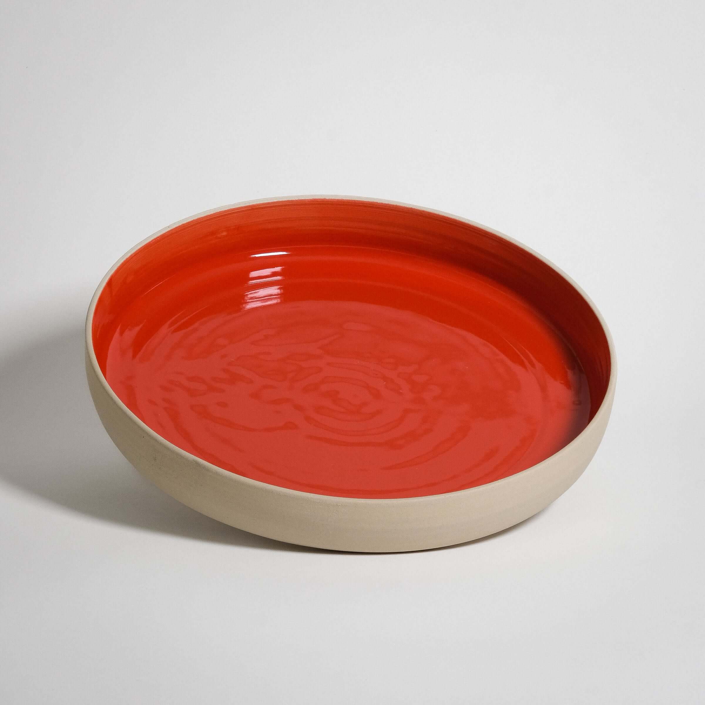 Handmade red serving bowl in high-quality stoneware, featuring a glossy glaze and durable ceramic for longevity.
