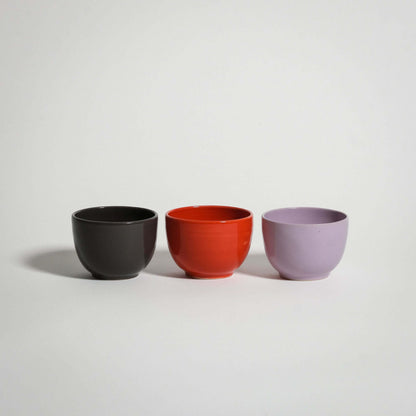 Set of three glazed espresso cups in red, lilac, and chocolate brown, perfect for coffee lovers.
