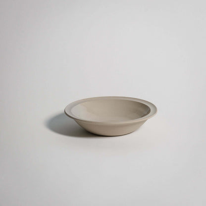 Elegant flat bowl in grey stoneware with a glossy interior glaze, perfect for serving small portions.