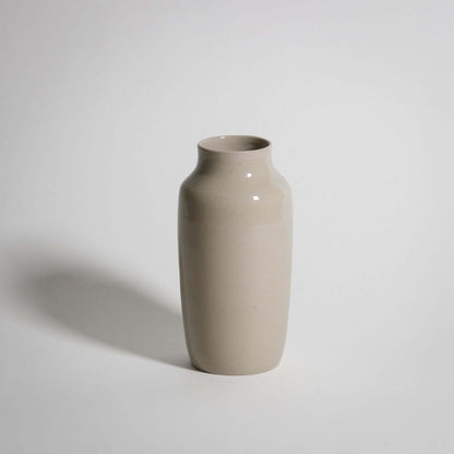 Handcrafted medium vase in creme stoneware with glossy glaze, perfect for enhancing any interior decor.