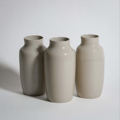 Set of three elegant handcrafted medium vases in creme color showcasing glossy stoneware finish.
