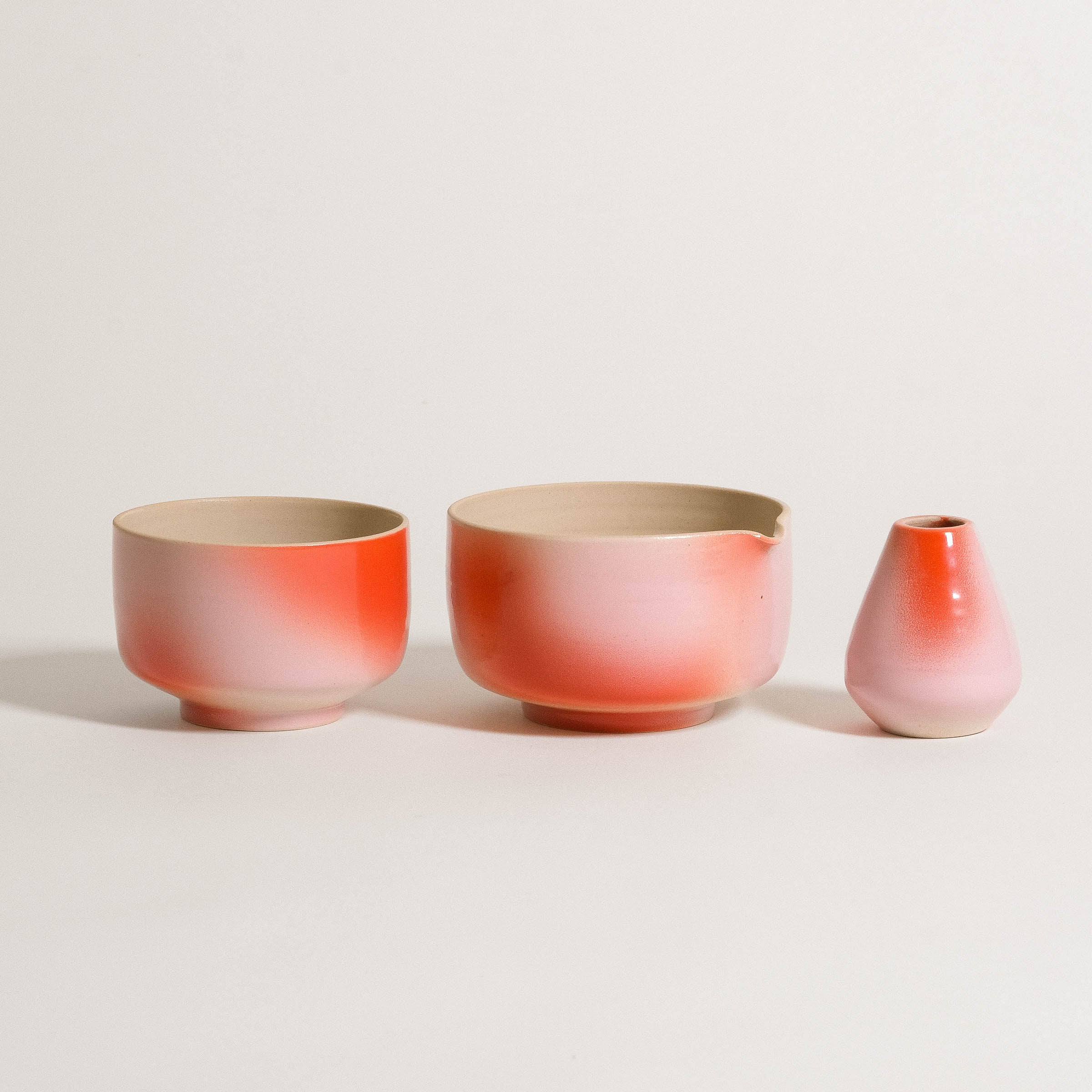 Handcrafted matcha pouring bowl set featuring a pink and red gradient, made from grey stoneware with glossy interior.
