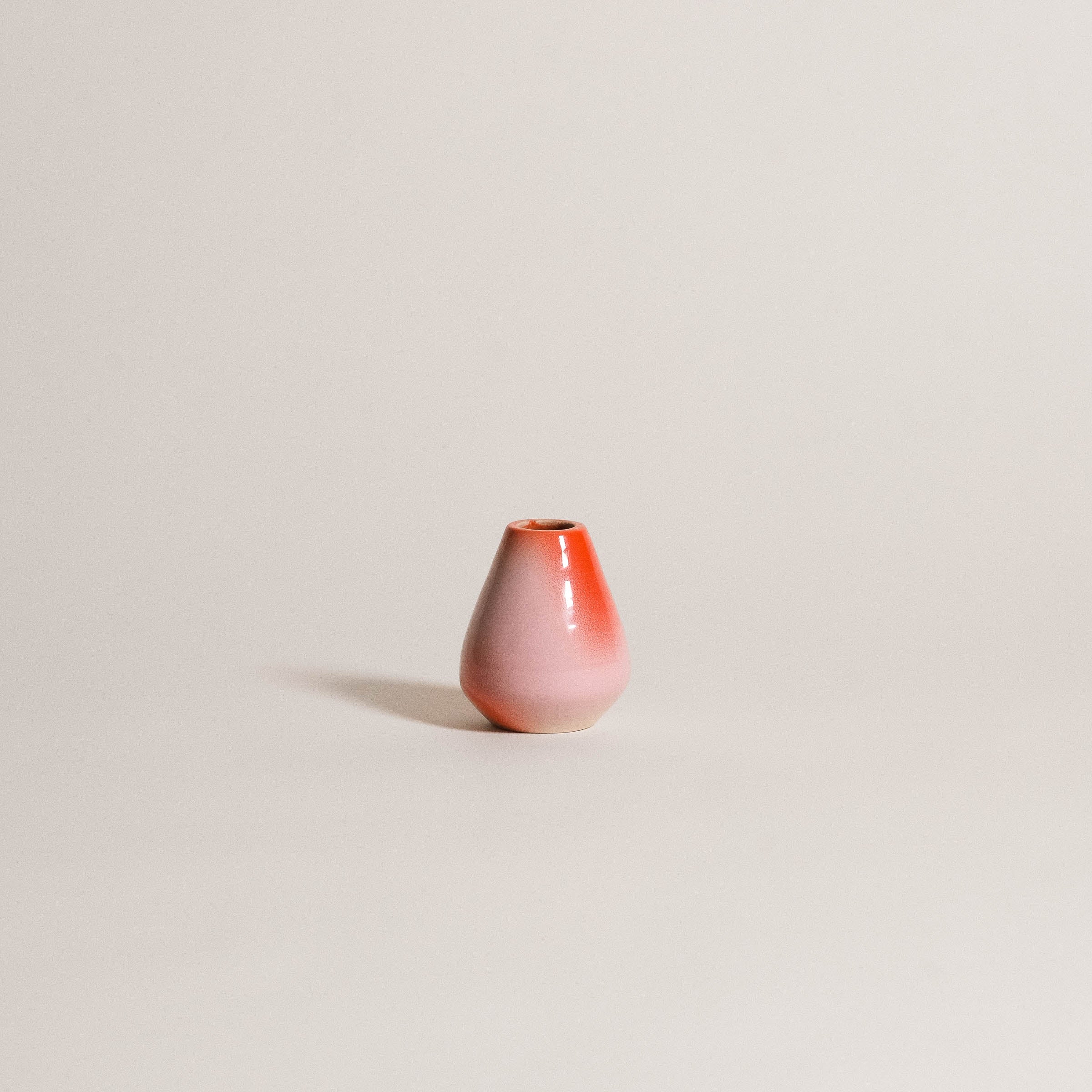 Handcrafted matcha whisk holder in soft pink and red gradient, made from grey stoneware clay.