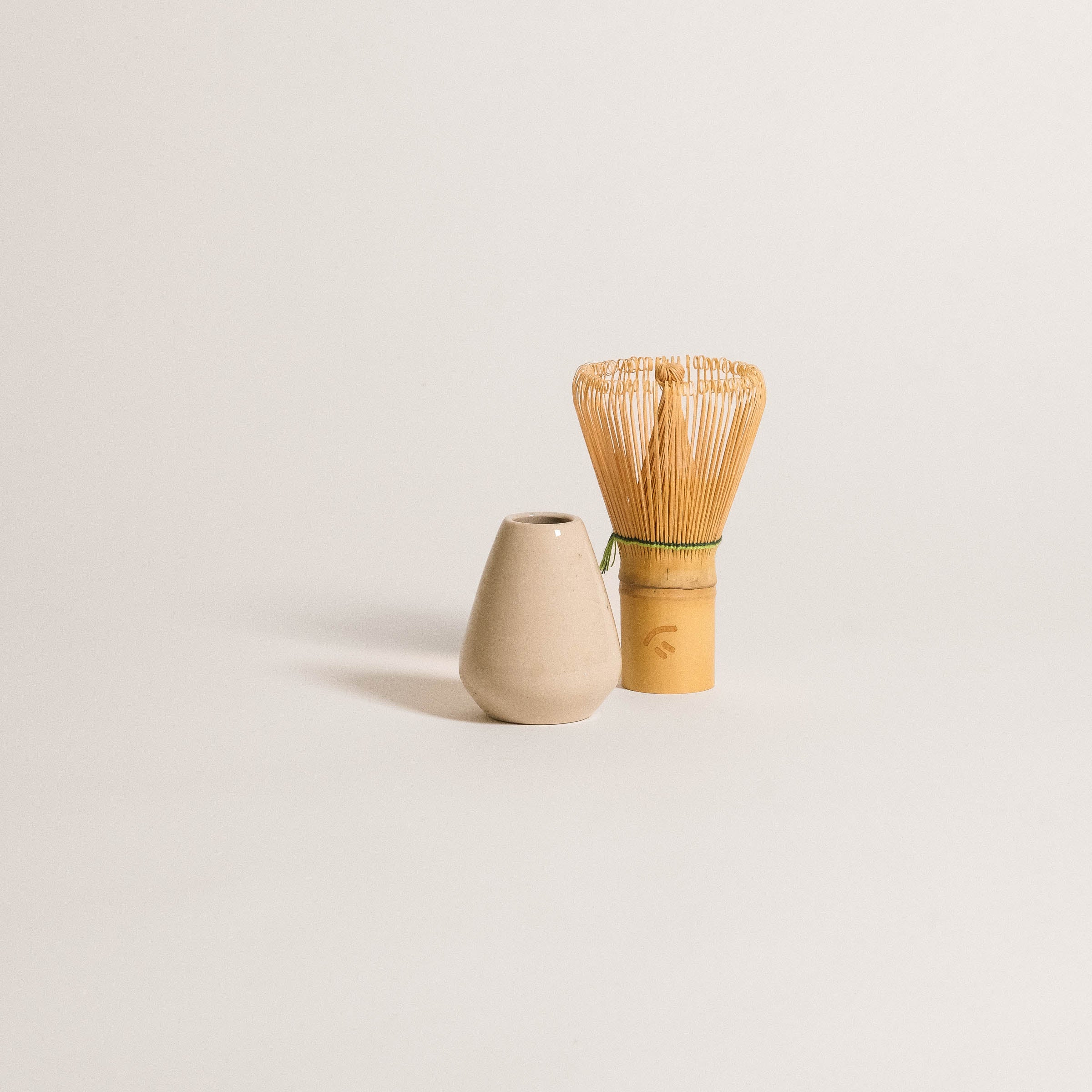 Matcha whisk holder in grey stoneware clay with bamboo whisk for matcha ritual, handcrafted in Germany.