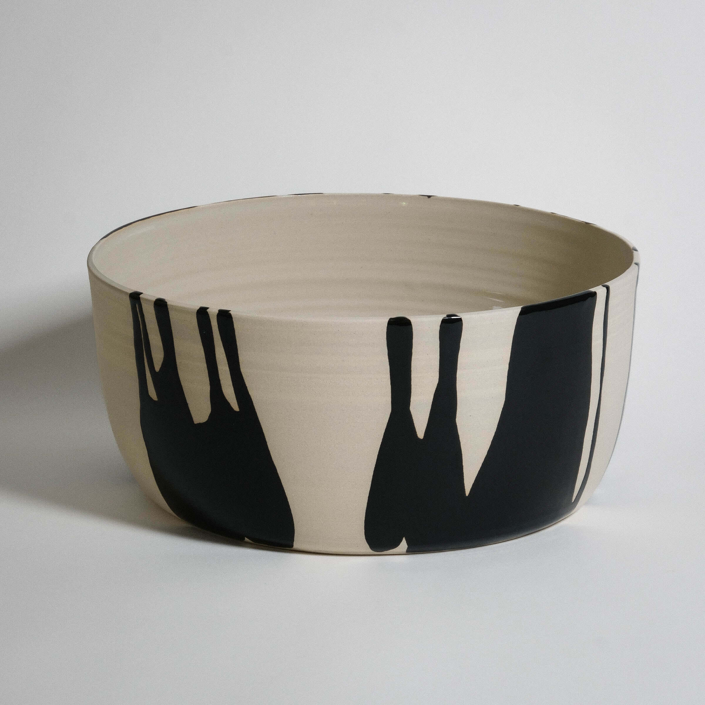 Handmade wide serving bowl crafted from stoneware with black and beige design, featuring smooth glossy glaze finish.