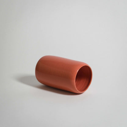 Handcrafted orange medium vase in a rounded shape, showcasing glossy stoneware finishes and unique craftsmanship.