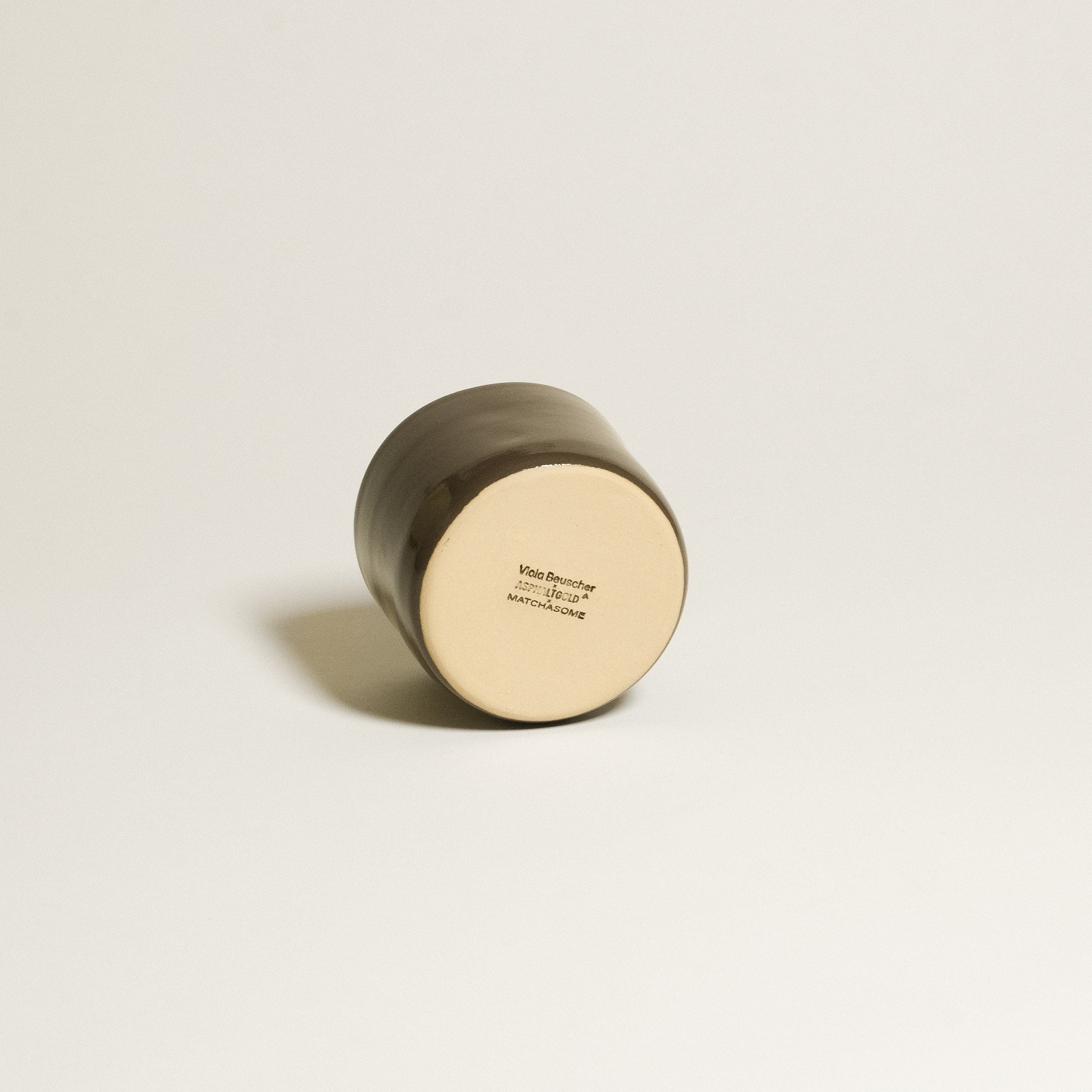 Hojicha Cup – Brown *COMING SOON* viewed from the bottom showcasing its smooth glazing and branding details.