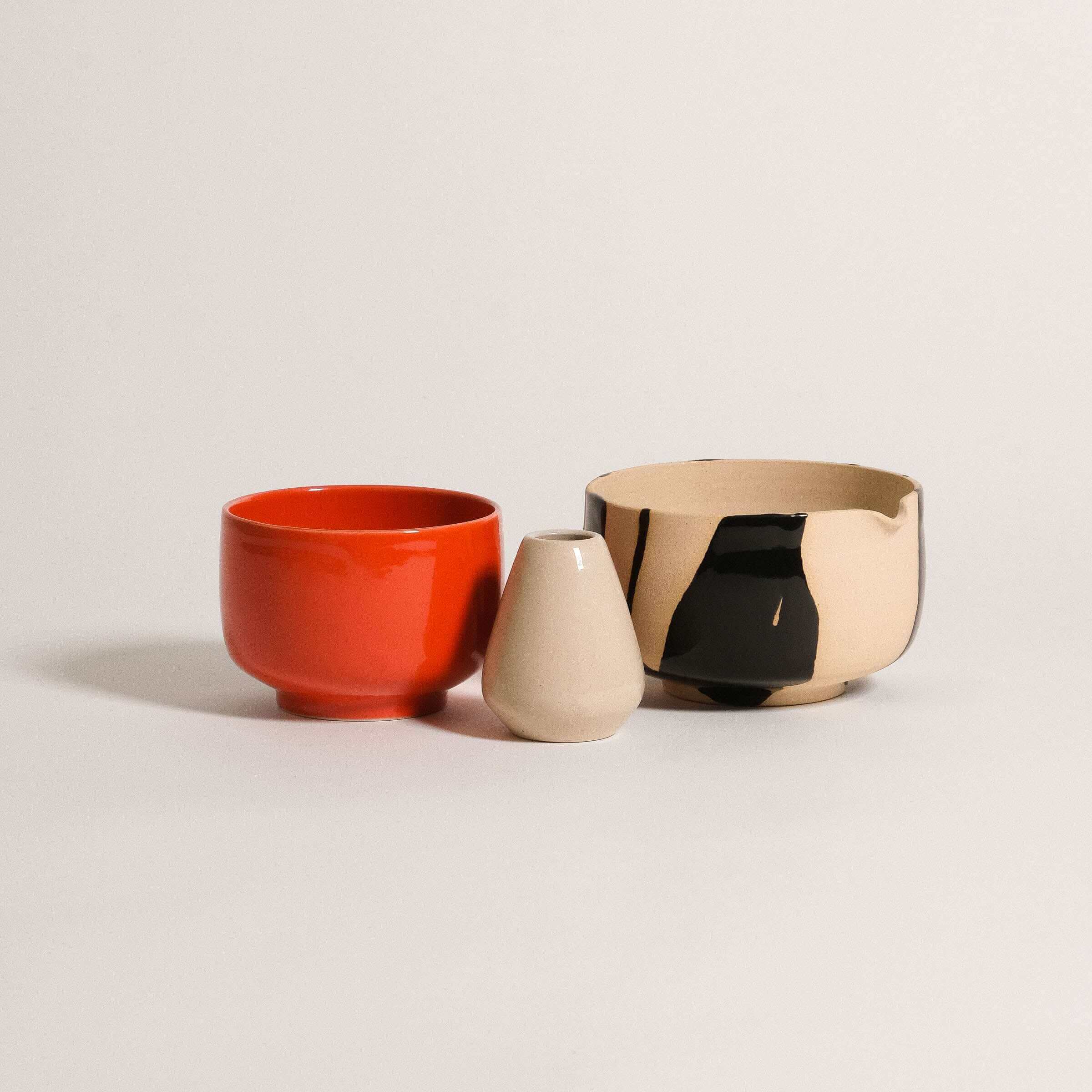 Viola Beuscher classic matcha set with glossy red cup, glazed whisk holder, and partially glazed pouring bowl.
