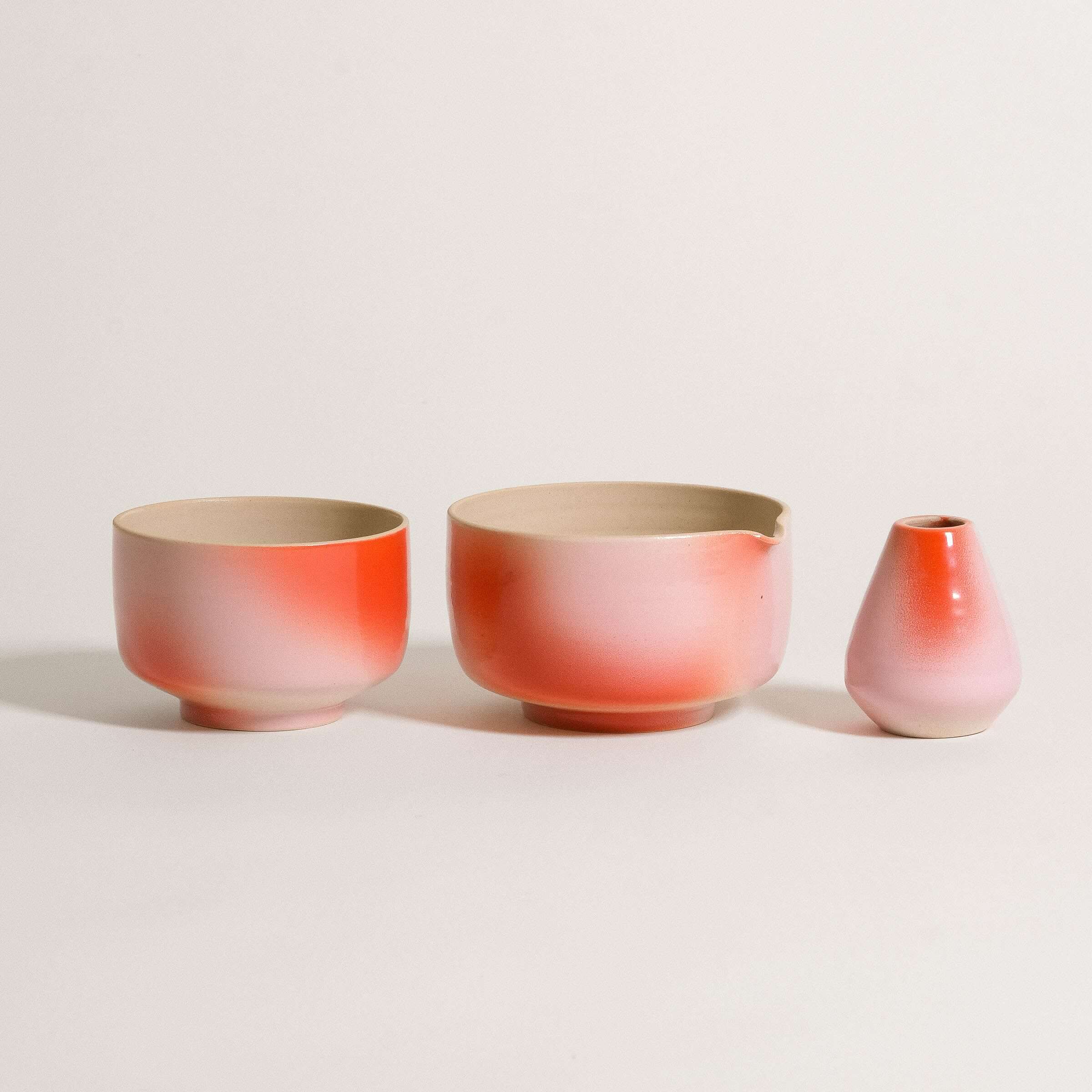 Hand-glazed matcha set in soft pink and red, including a pouring bowl, matcha cup, and whisk holder.