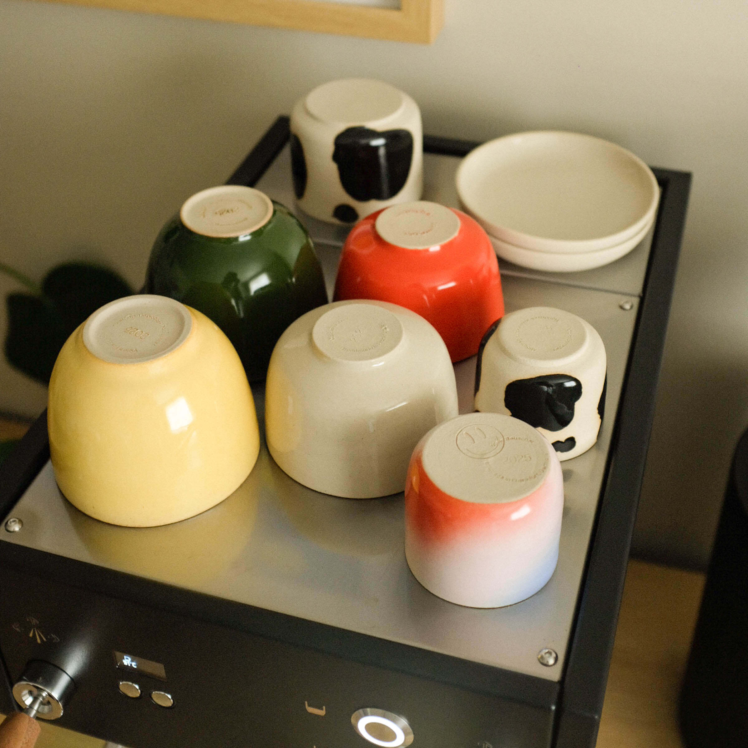 Mix & Match - Cup & Mug Bundle featuring colorful cups and a saucer on a modern display.