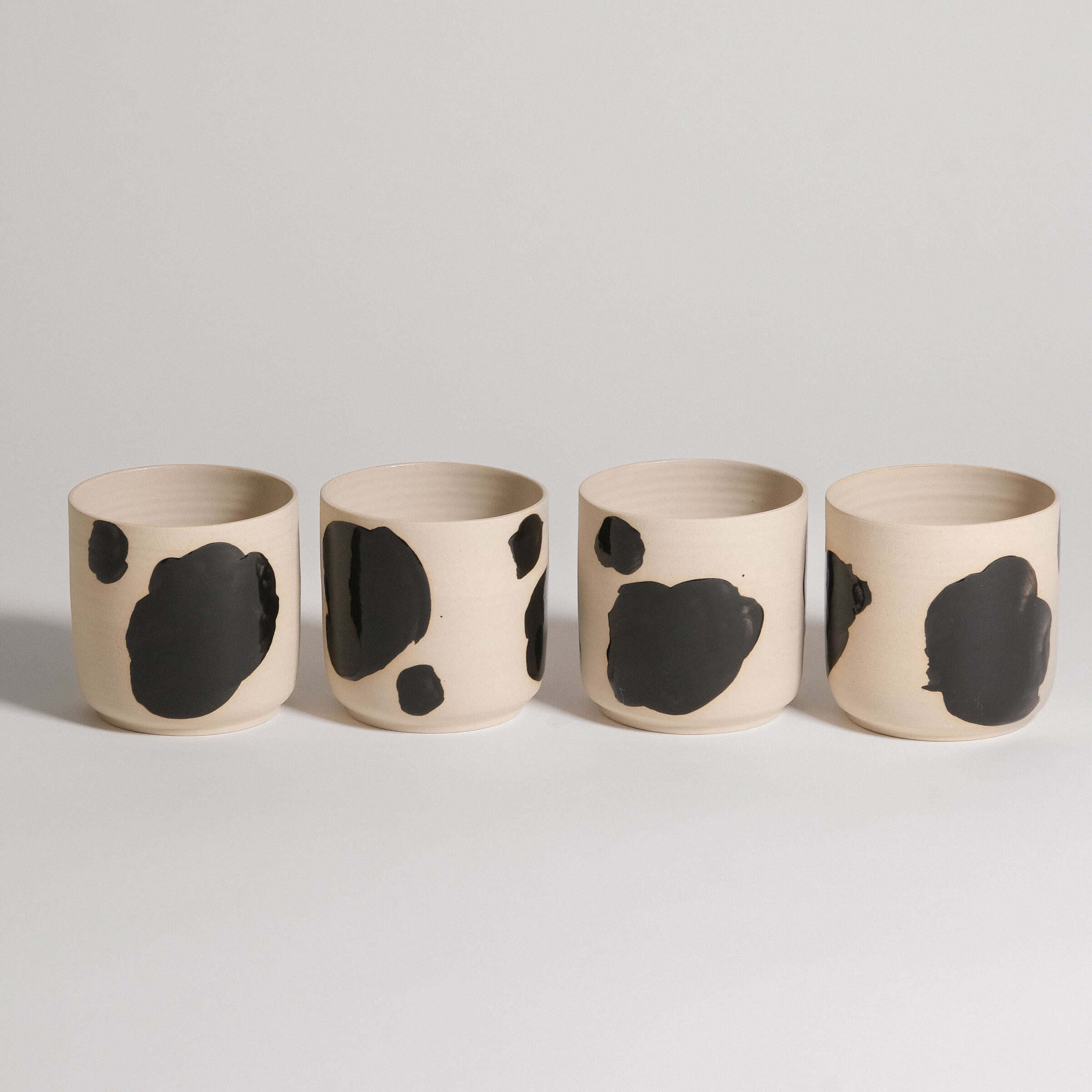 Set of 4 Nomi Pepe tea cups made from grey stoneware with black painted brush strokes.