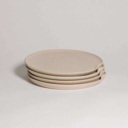 Set of four creme stoneware dinner plates with a glossy finish and easy stacking design.