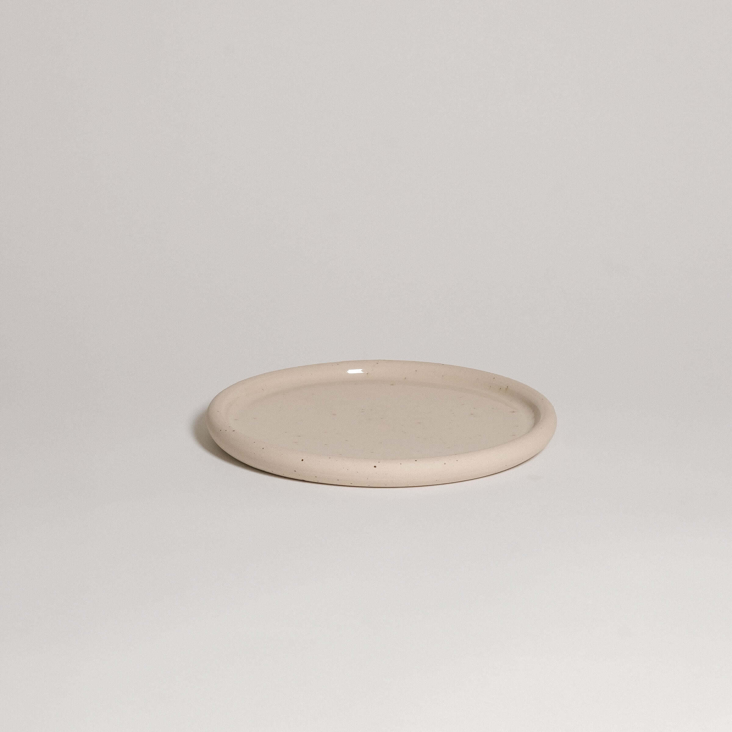 Lunch plate in spotted clay, wheel-thrown stoneware with a gently concave shape, food safe and dishwasher safe.